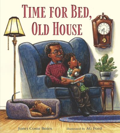 A grandfather sits in a large armchair with his grandson in his lap, reading a book.  His dog lays in a dogbed beside them, the clock on the wall shows 7:30. 